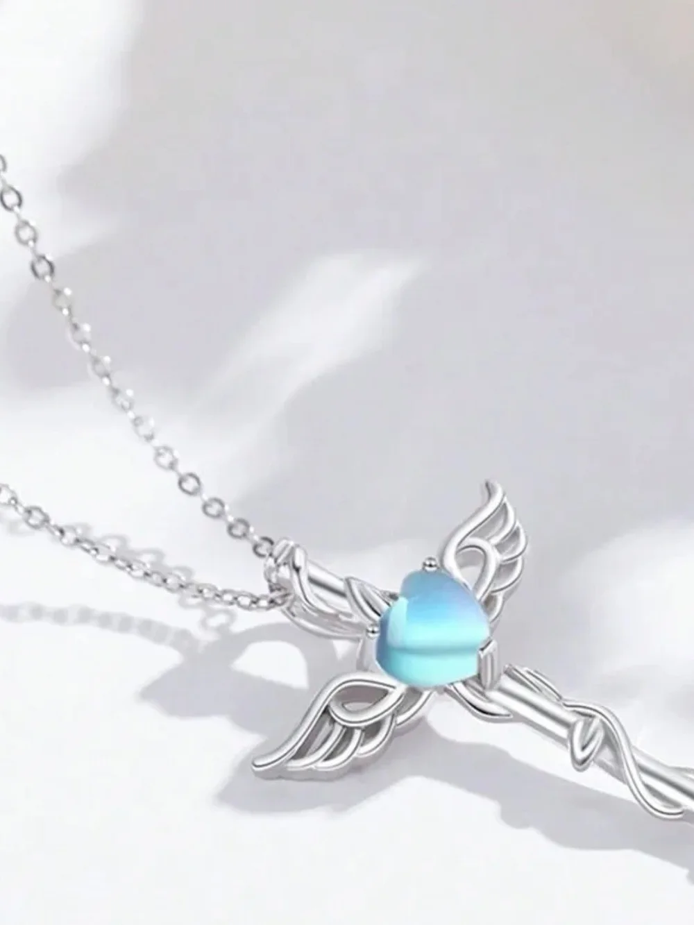 Silver Winged Cross Necklace with Blue Heart Gem